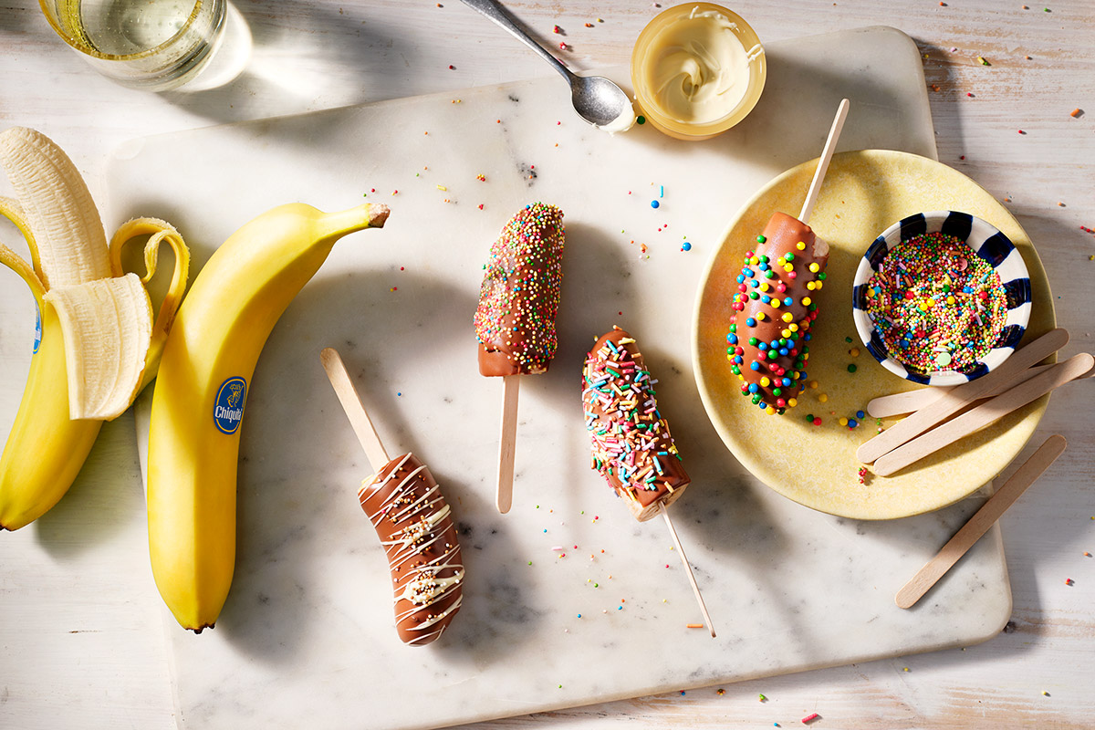 Polos de banana cubiertos de chocolate congelado con virutas (de colores)